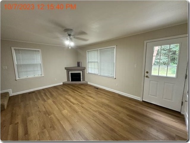 unfurnished living room with wood-type flooring and ceiling fan