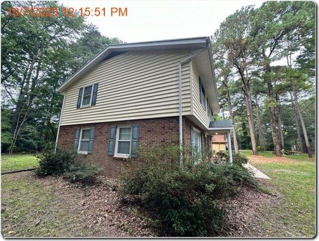 view of side of property with a lawn