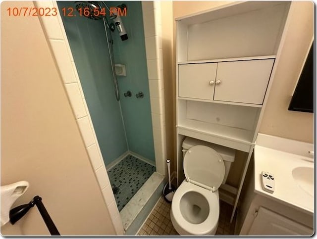 bathroom featuring toilet, a shower, and vanity