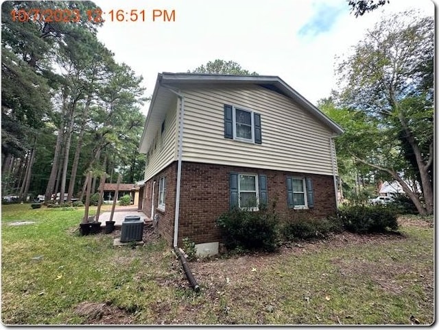 view of home's exterior with central AC and a lawn