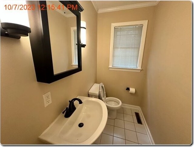 bathroom featuring tile patterned floors, toilet, ornamental molding, and sink