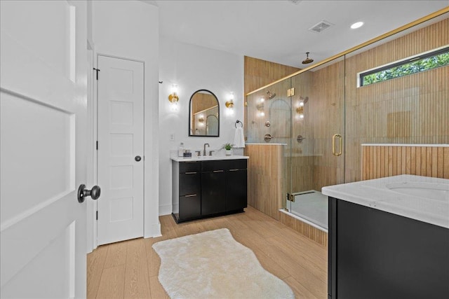 22231 Verlinda Lndg S, Cape Charles, VA 23310 - bathroom with a shower stall, two vanities, and wood finished floors