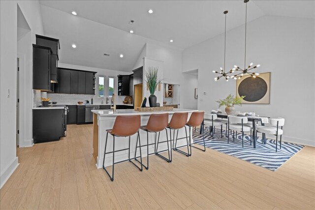 22231 Verlinda Lndg S, Cape Charles, VA 23310 - kitchen featuring dark cabinetry, dishwasher, light countertops, high vaulted ceiling, and a kitchen island with sink