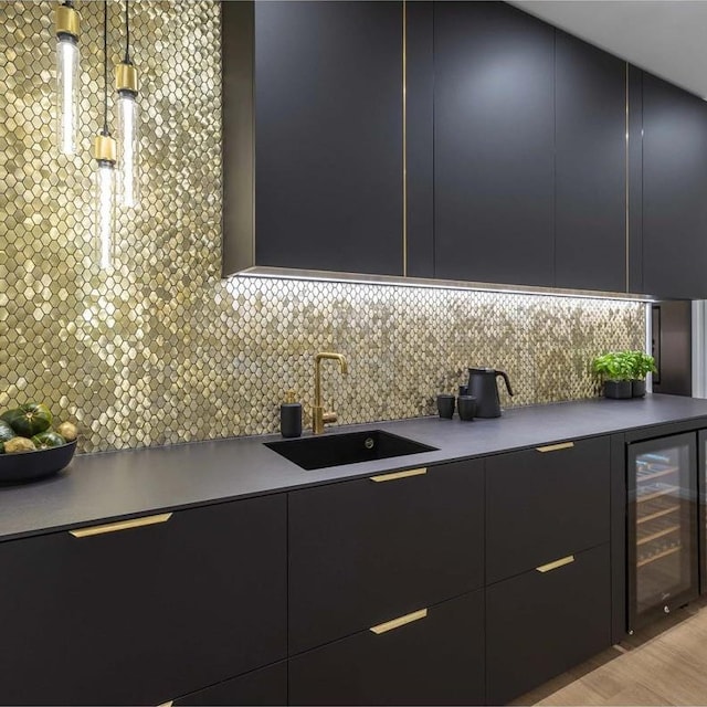 kitchen featuring sink, light hardwood / wood-style flooring, backsplash, decorative light fixtures, and beverage cooler