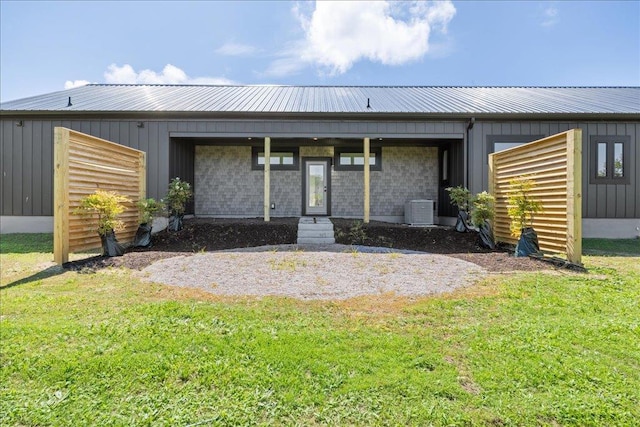 22231 Verlinda Lndg S, Cape Charles, VA 23310 - rear view of property featuring a lawn, cooling unit, metal roof, and board and batten siding
