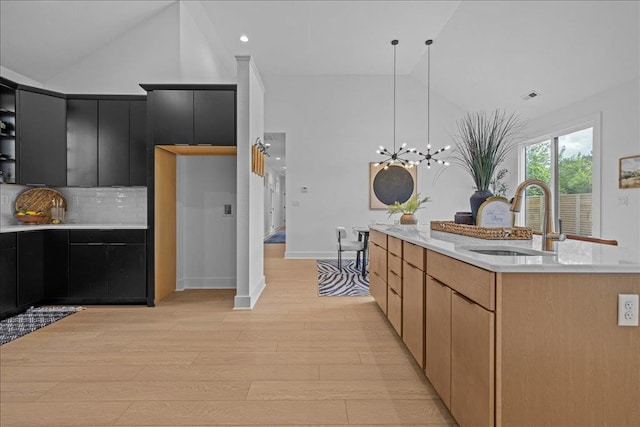 22231 Verlinda Lndg S, Cape Charles, VA 23310 - kitchen with a sink, dark cabinets, light countertops, light wood-style floors, and backsplash