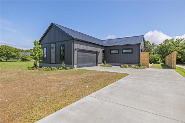 22231 Verlinda Lndg S, Cape Charles, VA 23310 - modern farmhouse featuring driveway, a front yard, an attached garage, metal roof, and board and batten siding