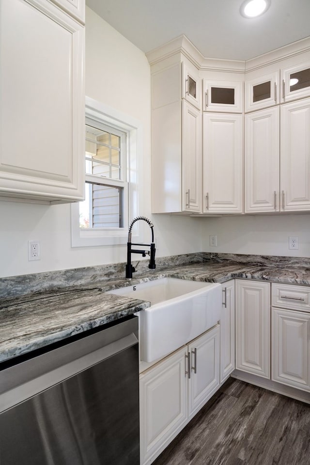 kitchen featuring dark wood-type flooring, sink, dark stone countertops, dishwasher, and white cabinetry