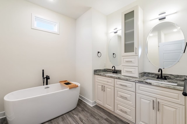 bathroom featuring hardwood / wood-style flooring, a bathtub, and vanity