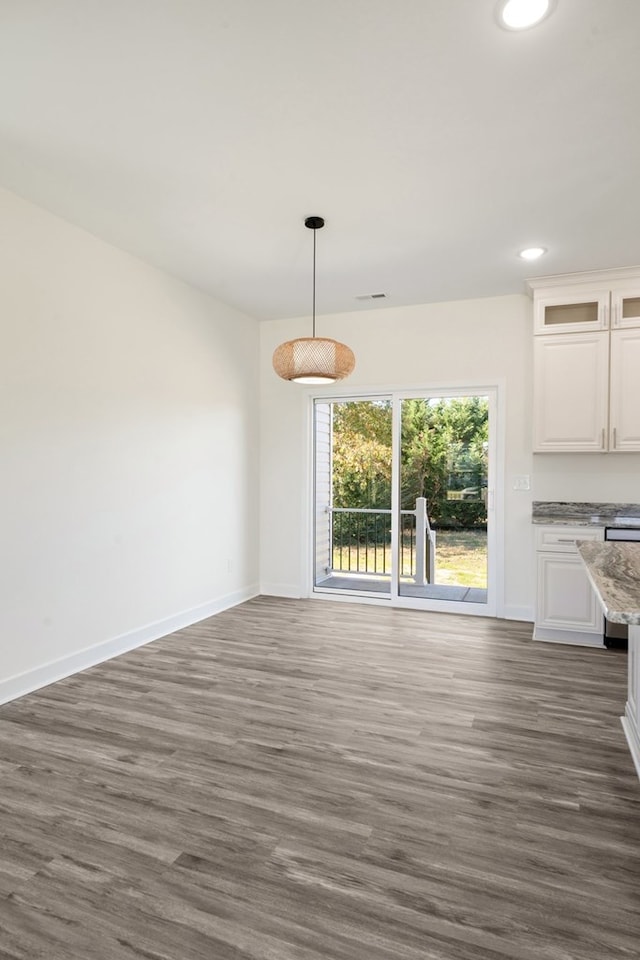 unfurnished dining area featuring dark hardwood / wood-style flooring