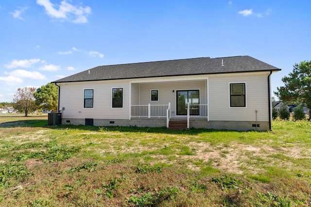 rear view of house with central AC unit, covered porch, and a yard