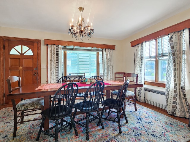 dining space featuring hardwood / wood-style floors, a healthy amount of sunlight, and a notable chandelier