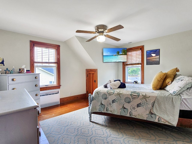 bedroom featuring ceiling fan, light hardwood / wood-style flooring, and vaulted ceiling