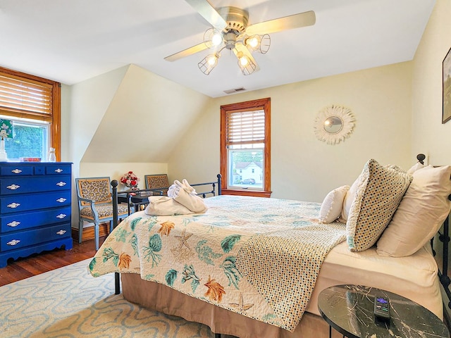 bedroom featuring dark hardwood / wood-style flooring, vaulted ceiling, and ceiling fan