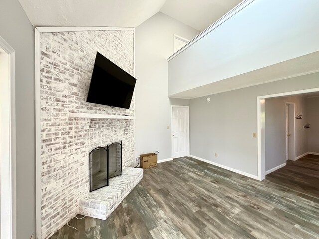 unfurnished living room featuring a fireplace, dark wood-type flooring, and lofted ceiling