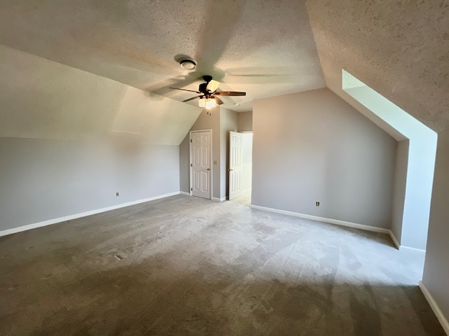 bonus room with vaulted ceiling with skylight, ceiling fan, a textured ceiling, and carpet