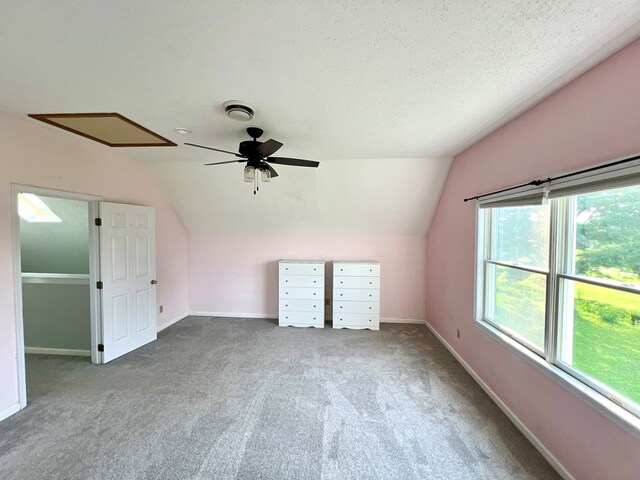 additional living space featuring ceiling fan, carpet floors, a textured ceiling, and vaulted ceiling