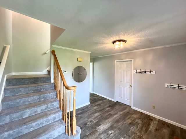 stairway with hardwood / wood-style floors, a textured ceiling, and crown molding