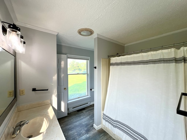 bathroom with ornamental molding, vanity, a textured ceiling, baseboard heating, and hardwood / wood-style floors