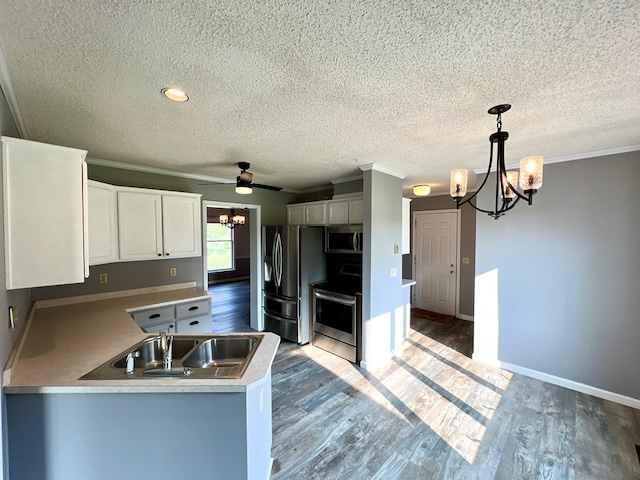 kitchen with white cabinets, ceiling fan with notable chandelier, stainless steel appliances, and decorative light fixtures