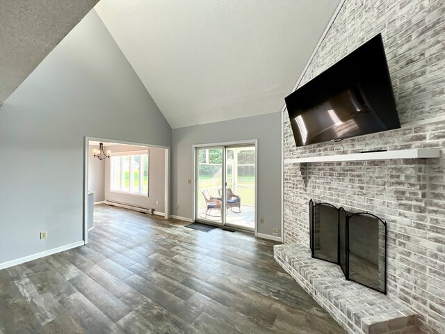 unfurnished living room featuring a baseboard radiator, high vaulted ceiling, a fireplace, hardwood / wood-style floors, and a chandelier