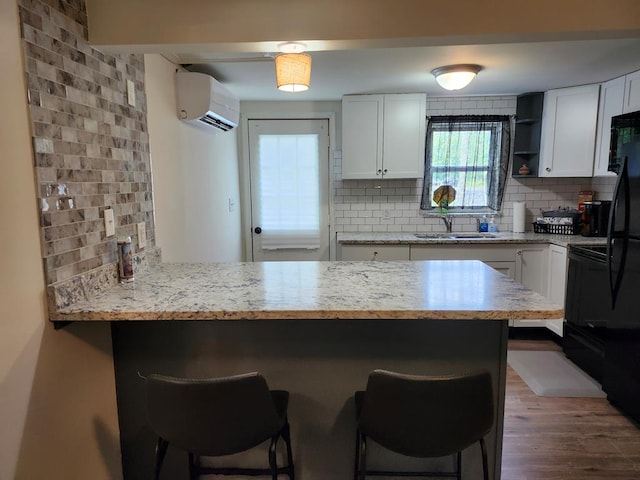 kitchen featuring white cabinets, decorative backsplash, and a kitchen breakfast bar