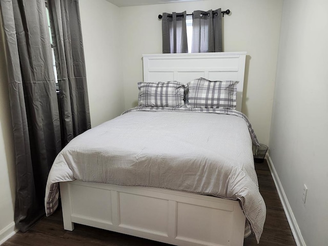 bedroom with dark wood-type flooring