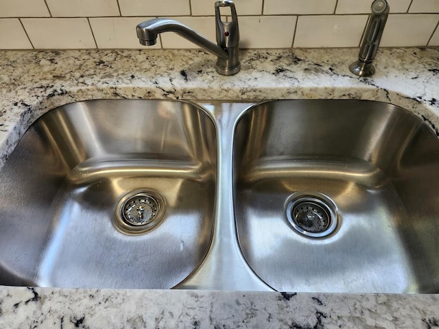 details featuring light stone countertops and sink