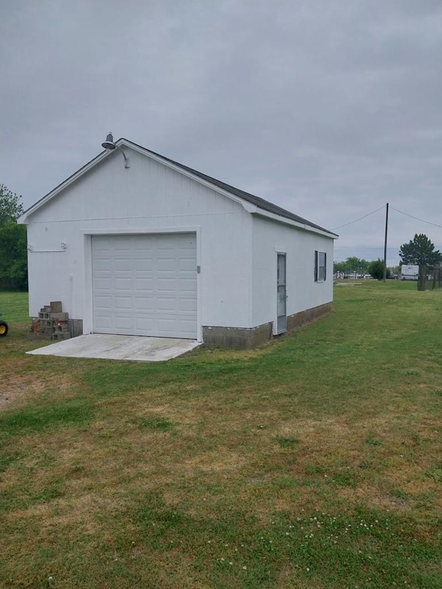 view of home's exterior featuring a lawn, a garage, and an outbuilding