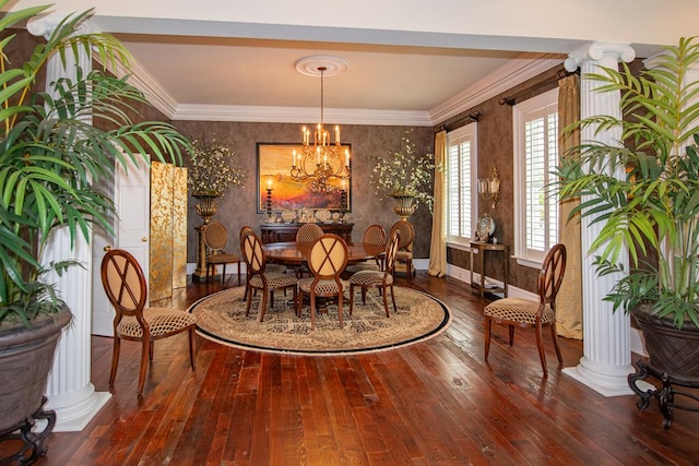 dining room with a notable chandelier, ornamental molding, hardwood / wood-style floors, wallpapered walls, and decorative columns