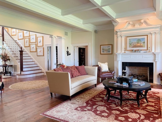 living room featuring hardwood / wood-style floors, beam ceiling, ornamental molding, and coffered ceiling