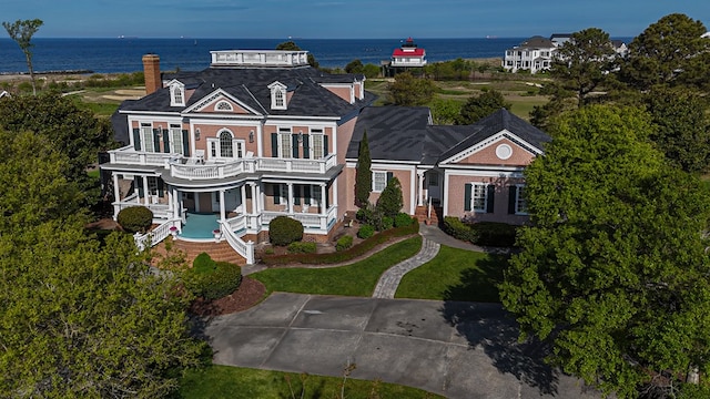 view of front facade with a balcony and a water view