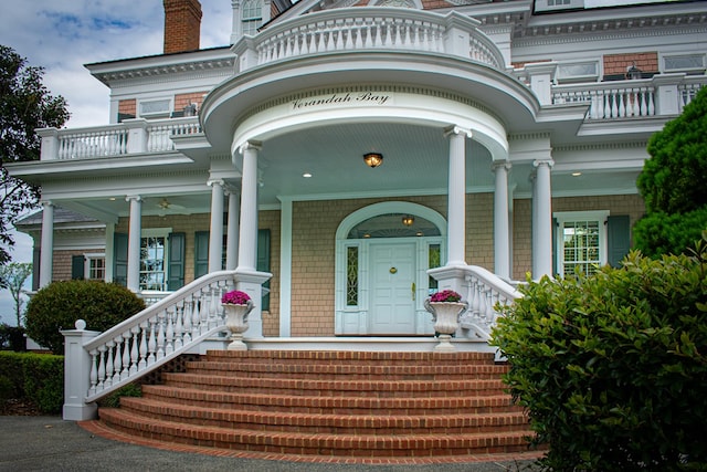 property entrance featuring covered porch and a balcony