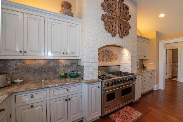 kitchen with double oven range, backsplash, dark wood-style floors, recessed lighting, and lofted ceiling