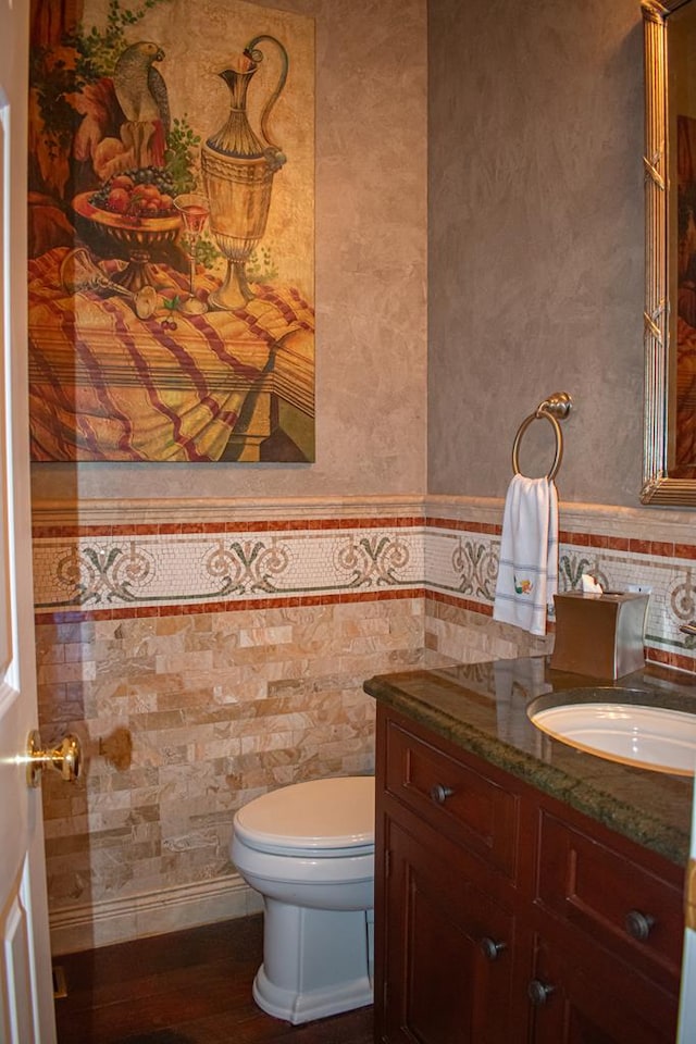 bathroom with vanity, hardwood / wood-style flooring, toilet, and tile walls