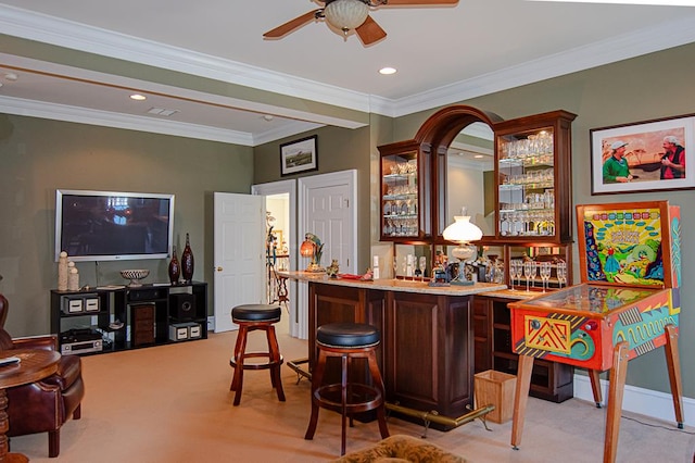 bar featuring crown molding, ceiling fan, and light carpet