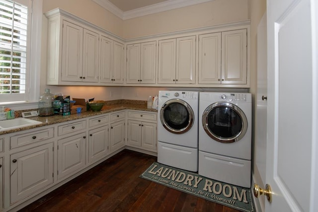 washroom featuring a sink, washing machine and dryer, cabinet space, crown molding, and dark wood-style flooring