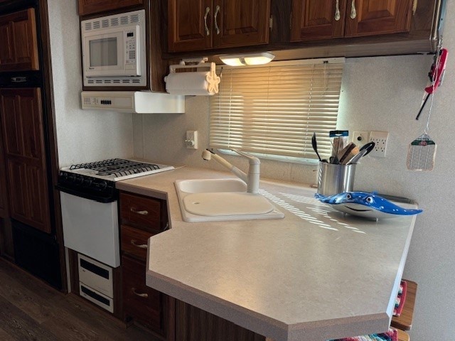 5196 Blue Heron Dr, Horntown, VA 23395 - kitchen with white appliances, a sink, light countertops, exhaust hood, and dark wood-style flooring