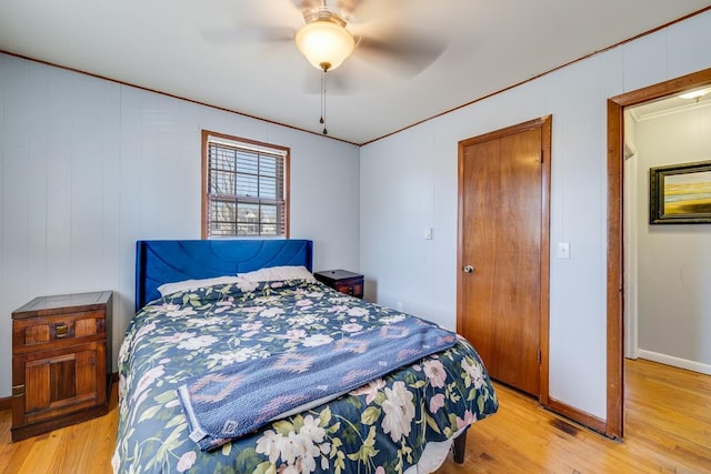 bedroom featuring a ceiling fan, light wood-style flooring, and baseboards