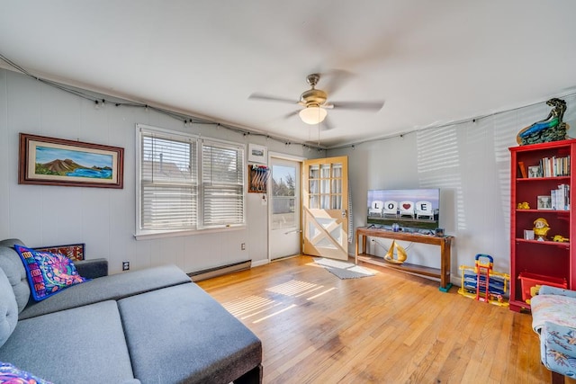 living area with ceiling fan, hardwood / wood-style floors, and baseboard heating