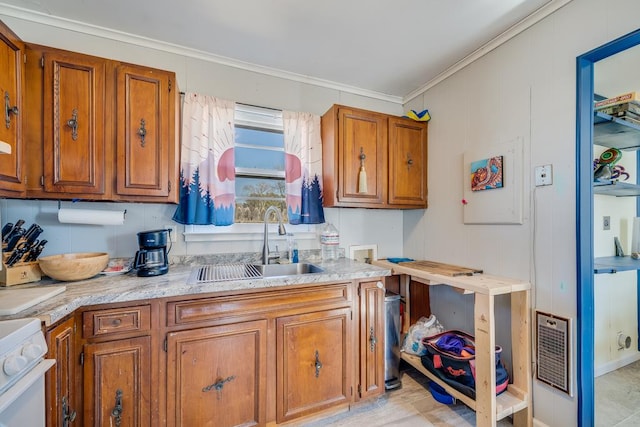 kitchen featuring ornamental molding, a sink, range, and brown cabinets