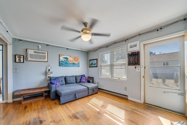 living room with light wood finished floors, baseboards, ceiling fan, a wall mounted air conditioner, and baseboard heating