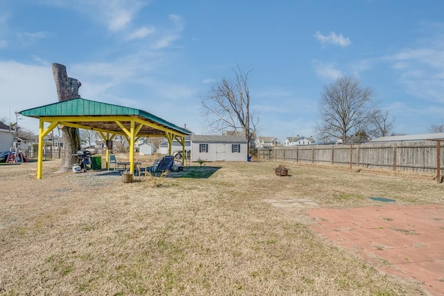 view of yard with an outdoor fire pit, a playground, an outdoor structure, fence, and a gazebo