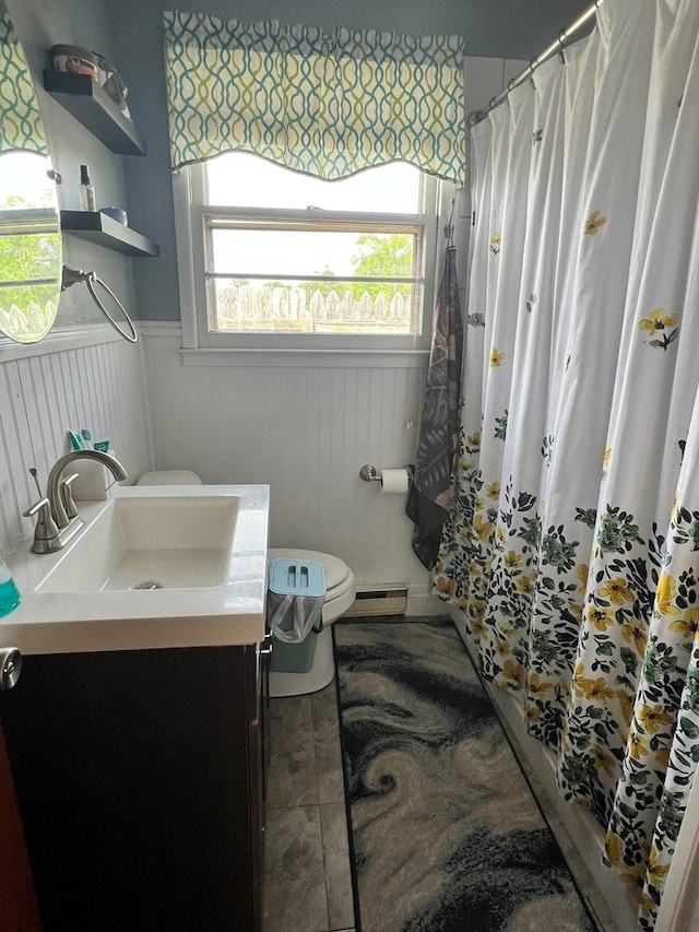 bathroom with toilet, vanity, a shower with shower curtain, and wainscoting