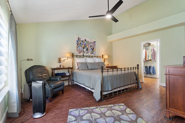 bedroom featuring dark wood-type flooring, a spacious closet, vaulted ceiling, a closet, and ceiling fan