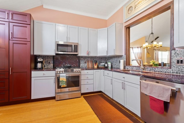 kitchen with pendant lighting, stainless steel appliances, and white cabinets