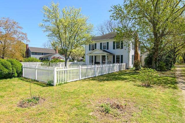 back of property with a fenced front yard and a lawn