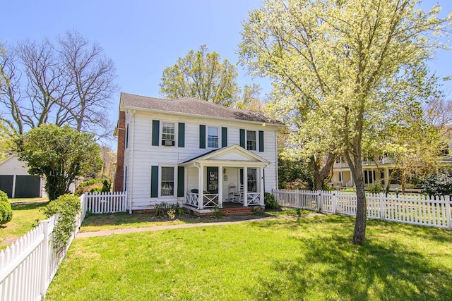 colonial-style house featuring a fenced backyard, a front lawn, and covered porch