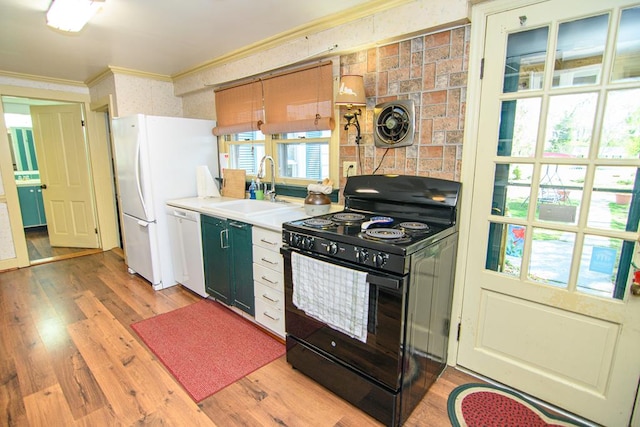 kitchen with white appliances, light wood-type flooring, ornamental molding, visible vents, and a sink