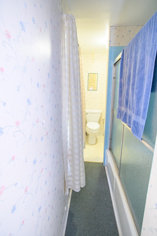 bathroom featuring shower / bath combination with glass door and toilet